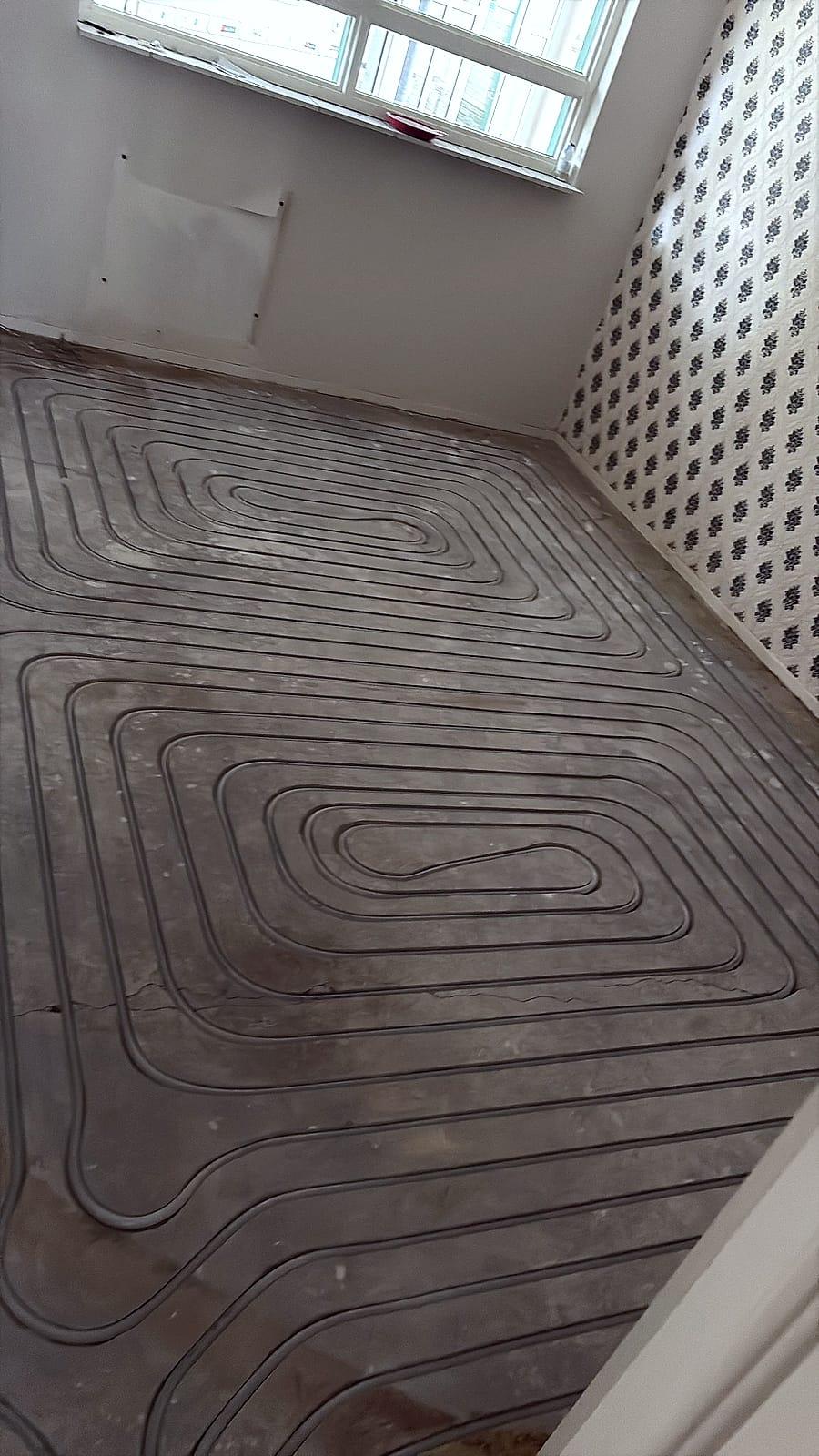 Ingefreesde vloerverwarming in een woonkamer tijdens renovatie